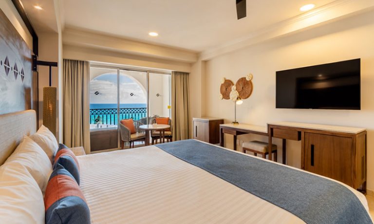 King-size bed in the Deluxe Ocean View Room with jacuzzi, offering luxurious comfort and stunning vistas for a relaxing stay