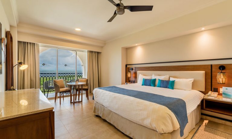 Deluxe Lagoon View Room: Comfortable king-size bed with plush bedding, overlooking tranquil lagoon waters.