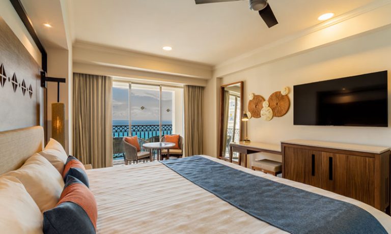 Spacious king-size bed with luxurious linens and panoramic ocean views.