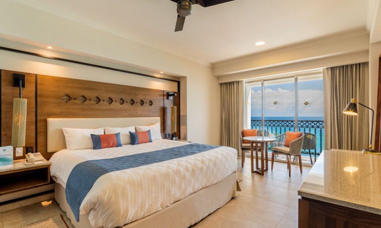 King-size bed with plush bedding, offering ultimate comfort and stunning oceanfront vistas.