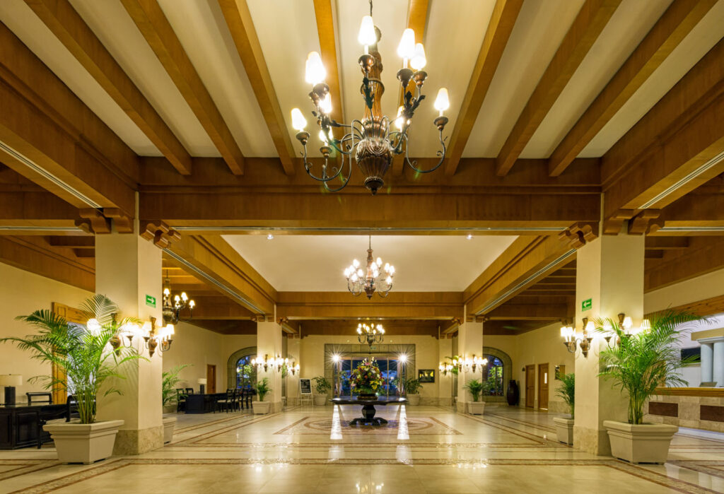 Lobby con candelabros y techo de madera y pilares cuadrados